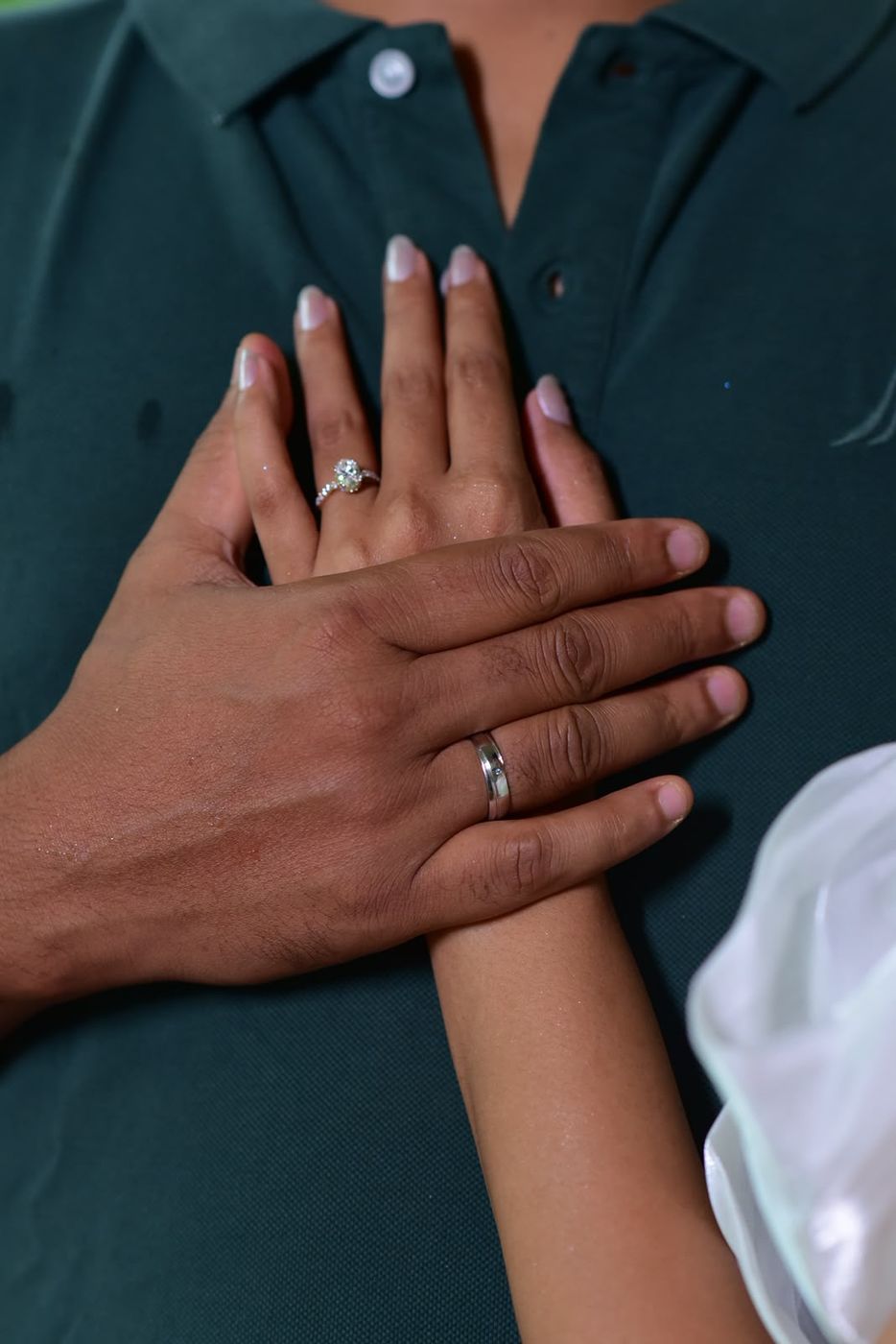 Their hands with engagement rings